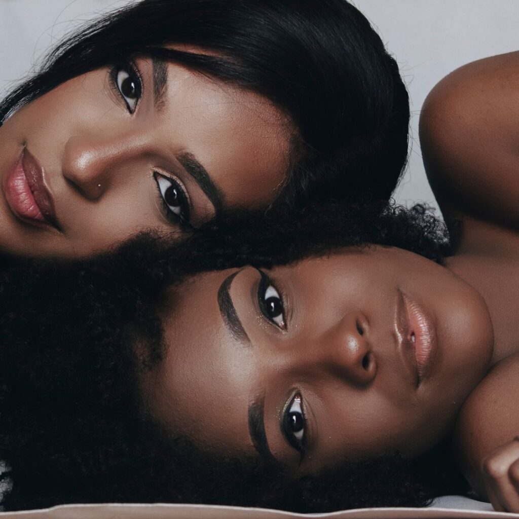 Two beautiful black woman with their heads laaying on eachother representing the process of me embracing my dark skin through finding a community that feels like my safe space. 