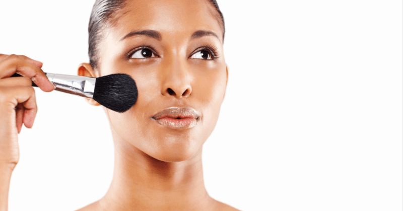 Woman applying foundation to her oily skin